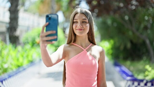 Young beautiful girl smiling confident making selfie by the smartphone at park