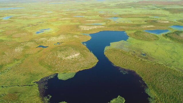 Slow backward drone flight over a high altitude mountain plateau (fj&auml;ll) with swamps and lakes in central Sweden
