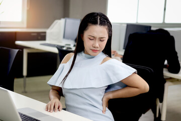 Fototapeta na wymiar Tired beautiful Asian woman officer relieve physical tension during take break from work at office, exhausted female feels pain in back, office syndrome, need resting and stretching body at workplace.