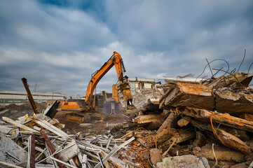 Fototapeta premium Excavator destroyer with hydraulic scissors cuts concrete