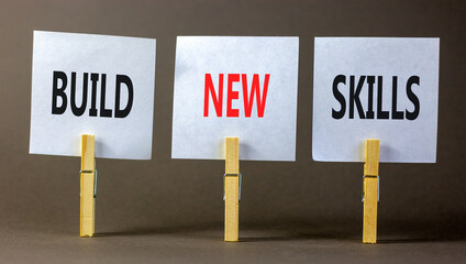 Build new skills symbol. Concept word Build new skills on beautiful white paper on wooden clothespin. Beautiful grey table grey background. Business, education build new skills concept. Copy space.
