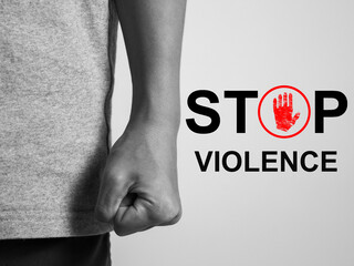 Message stop violence Using force to harm others The hands of a violent person clenched in a black and white image.