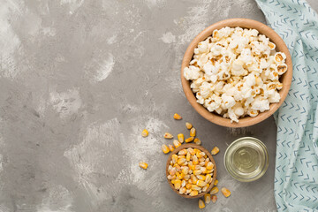 Fototapeta na wymiar Prepared popcorn with ingredients on concrete background, top view