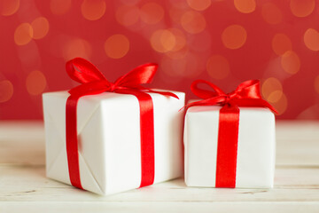 Christmas gifts on table against blurred lights