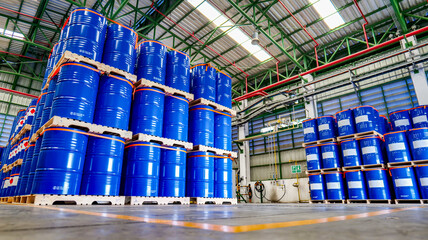 Blue 200 liter chemical and oil drums arranged on pallets. Stored in an orderly warehouse. to wait...