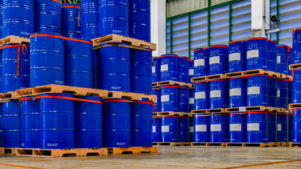 Blue 200 liter chemical and oil drums arranged on pallets. Stored in an orderly warehouse. to wait...