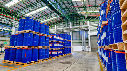 Blue 200 liter chemical and oil drums arranged on pallets. Stored in an orderly warehouse. to wait...