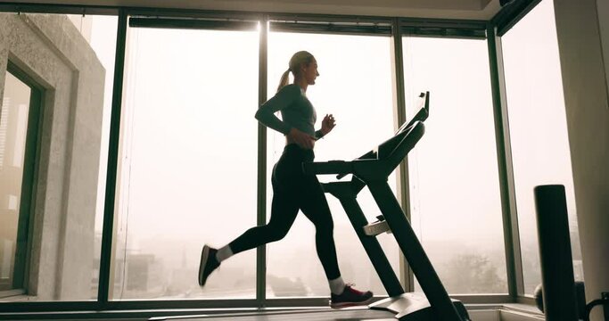 Woman, running on treadmill and fitness in gym with cardio and challenge, speed and wellness with health. Exercise, training and runner on workout machine, endurance and active, athlete and sports