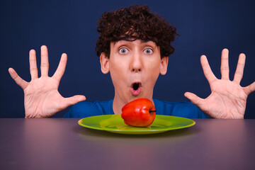 A young funny guy eats an apple. Vegetarianism and a healthy lifestyle.