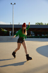 Teenager girl inline skating on boardwalk making stunt and tricks