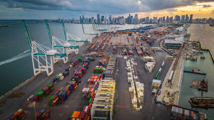 Miami port florida import export cargo container and crane cityscape at sunset 
