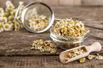 Dry chamomile flowers on a wooden table. Soothing chamomile tea. Herbal drink. flat layout. Space for text.Copy space.Medical prevention and immune concept. Folk alternative medicine.