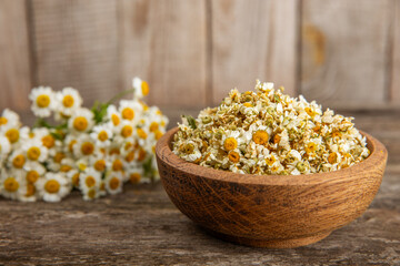 Dry chamomile flowers on a wooden table. Soothing chamomile tea. Herbal drink. flat layout. Space for text.Copy space.Medical prevention and immune concept. Folk alternative medicine.