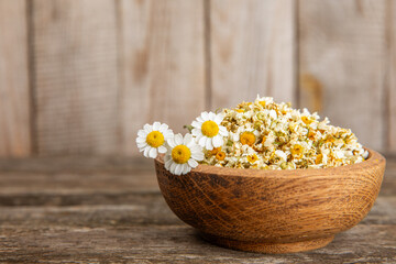 Dry chamomile flowers on a wooden table. Soothing chamomile tea. Herbal drink. flat layout. Space for text.Copy space.Medical prevention and immune concept. Folk alternative medicine.