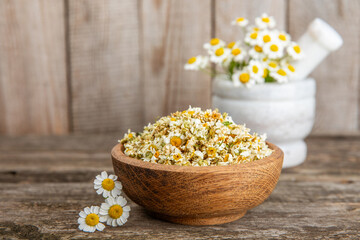 Fototapeta na wymiar Dry chamomile flowers on a wooden table. Soothing chamomile tea. Herbal drink. flat layout. Space for text.Copy space.Medical prevention and immune concept. Folk alternative medicine.