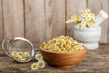 Dry chamomile flowers on a wooden table. Soothing chamomile tea. Herbal drink. flat layout. Space for text.Copy space.Medical prevention and immune concept. Folk alternative medicine.