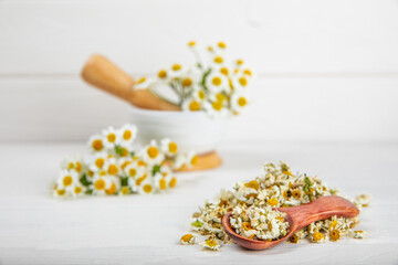 Dry chamomile flowers on a wooden table. Soothing chamomile tea. Herbal drink. flat layout. Space for text.Copy space.Medical prevention and immune concept. Folk alternative medicine.