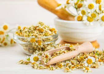 Dry chamomile flowers on a wooden table. Soothing chamomile tea. Herbal drink. flat layout. Space for text.Copy space.Medical prevention and immune concept. Folk alternative medicine.
