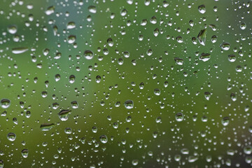 Lots of raindrops on the window. Rainy season concept. Climate change. Wet in rain. Focus on water droplets on window.