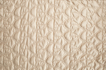 intricate sewing on beige fabric,  abstract background