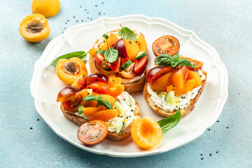 Gourmet sandwiches bread toast, bruschetta with cream cheese, peaches, tomatoes and green basil...