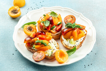 Gourmet sandwiches bread toast, bruschetta with cream cheese, peaches, tomatoes and green basil leaves