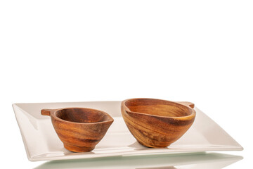 Two wooden cups on a white ceramic tray, macro, isolated on white background.