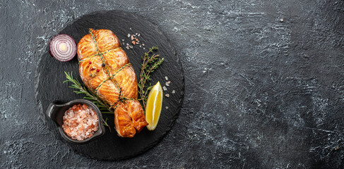 delicious salmon steak with spices and herbs on a dark background, Long banner format. top view