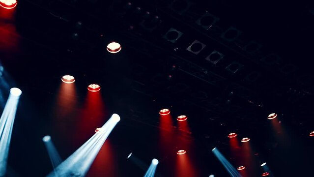 working ceiling spotlights lightning on a stage during the musical concert