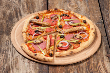 Studio shot of a hand made pizza on beautiful weathered wooden table