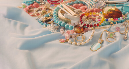 different women's jewelry on blue fabric