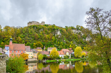 Fototapeta na wymiar River Naab in summer with town houses and Church of Saint Michael in background, Kallmünz, Germany