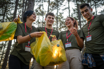 portrait of group of friends volunteers prepare to collect garbage waste and clean forest nature in...