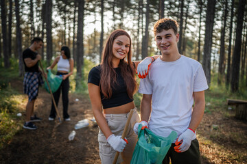 portrait couple in front of group of friends volunteers prepare to collect garbage waste and clean forest nature in summer day slow motion