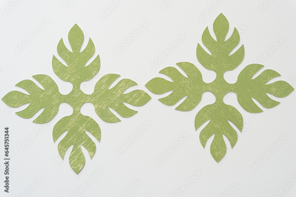 Sticker two quad-palmette decor shape machine-cut from paper and arranged on blank paper