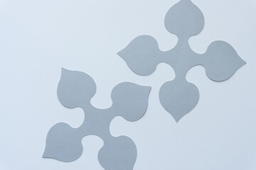 two gray spade-like quadrilateral machine-cut paper designs or shapes on blank paper