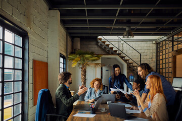 Young and diverse group of designers having a meeting in an office while working in a startup company