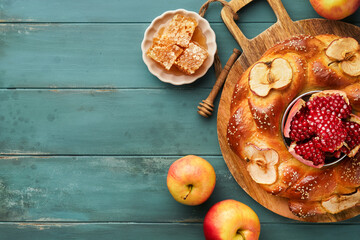 Jewish Holidays - Rosh Hashanah or Rosh Hashana. Pomegranate, apples, honey and round challah on  old wooden blue table background. Jewish Autumn celebration. Shana Tova. Yom kippur concept. Top view