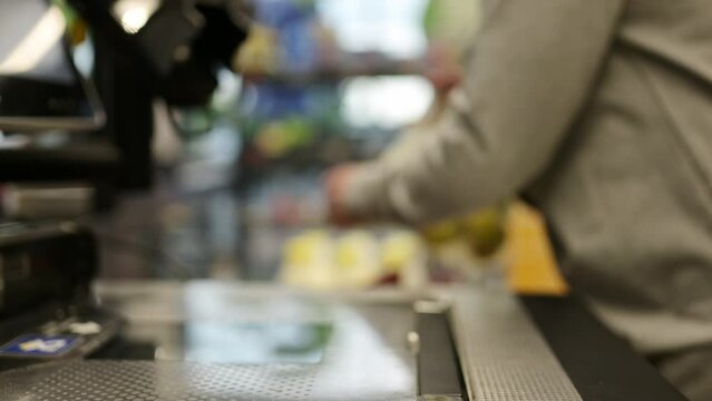 girl Waights a plastic bag with a apples on a self-service checkout