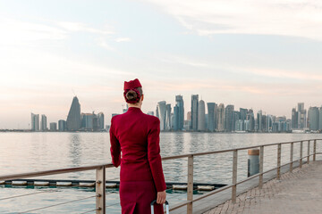 View from the back at unrecognisable Qatar Airways cabin crew, walking at the promenade in Doha...