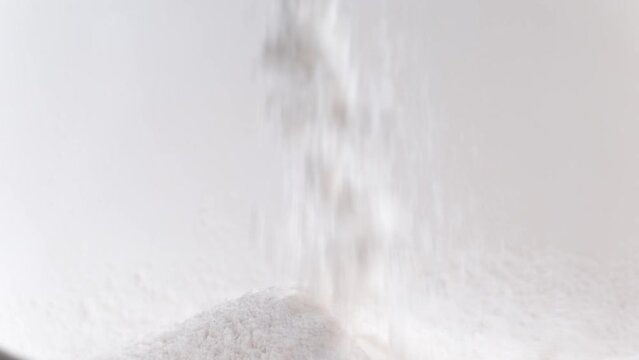 White cereal flour pouring in plate for healthy pie preparation in bakery. Wheat powder for fresh homemade bread and pastry