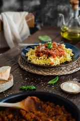 Plato de pasta con salsa boloñesa encima de una mesa rústica