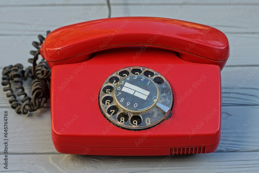 Canvas Prints landline, rotary with dialer plastic old classic red office with black wire telephone stands on a gray wooden table