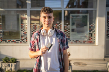 portrait of teenager man stand in front of bank ATM hold credit card