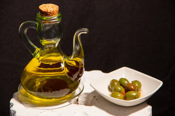 Drizzle of extra virgin olive oil from Spain, next to a plate of green olives