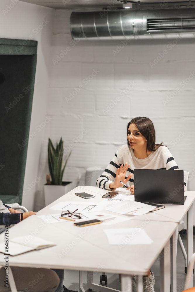 Wall mural brunette female employee talking business with her male colleagues