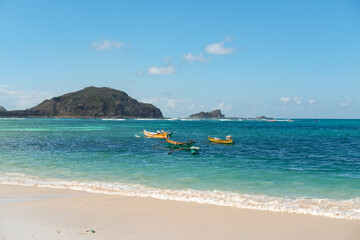 beautiful view at Tanjung Aan beach Lombok, colorful boats on the beach, blue sea and blue sky, kuta mandalika, traditional fishing boat, hidden gem in Lombok