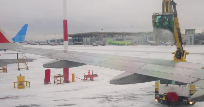 De icing of airplane before flight. Anti-icing is the application of chemicals that not only deice but also remain on a surface and continue to delay the reformation of ice