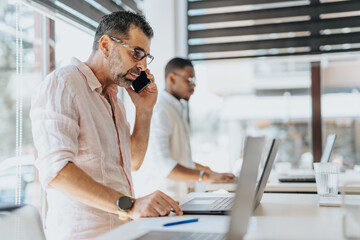 Mature businessman negotiation with client during phone call.