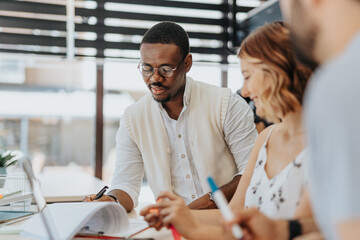 Marketing professionals collaborate in a diverse office, focusing on brand management, communication, and content strategy to engage customers and optimize marketing campaigns.